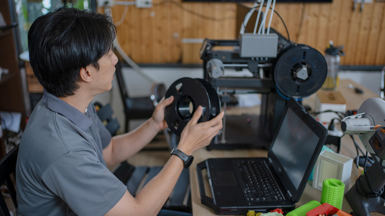 A person setting up a 3D printer.