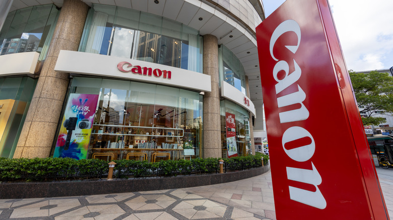 Canon retail store exterior with large red logo and glass storefront.