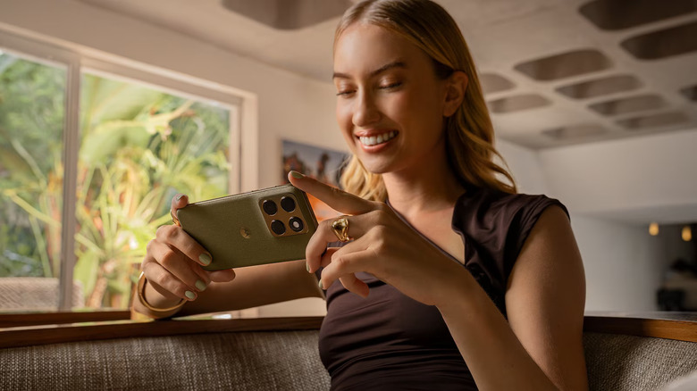 A person holding Motorola Edge in landscape while sitting down