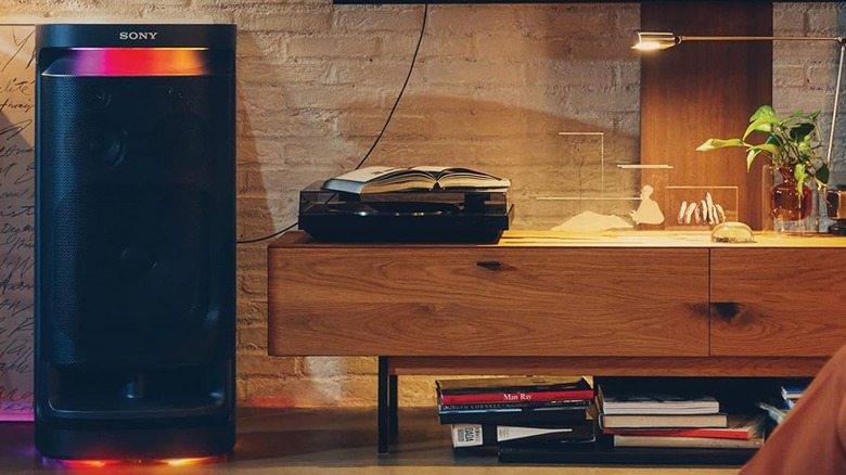 The Sony SRS-XV900 set up next to a wall-mounted TV. It's connected to the TV via digital optical.