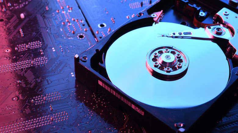 Close-up of a hard drive physical disc used to store data, with a circuit board background.