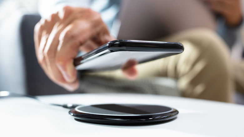 Placing a phone on a wireless charging mat.