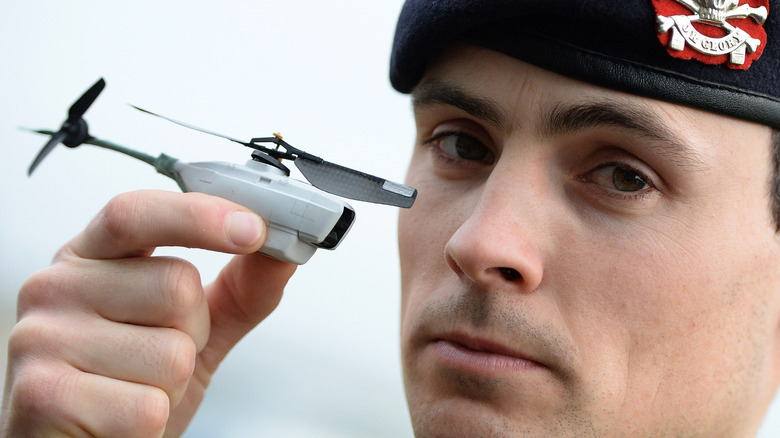 A British soldier holds a Black Hornet drone.