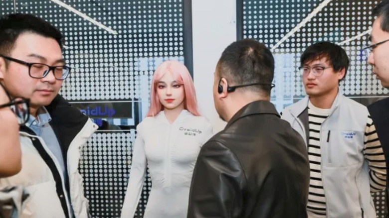 Several people gathered around the DroidUp Moya robot