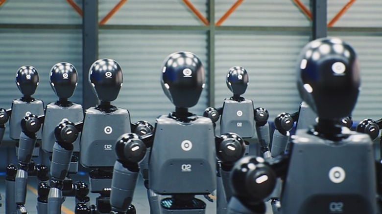 humanoid robots in a line within a warehouse facility