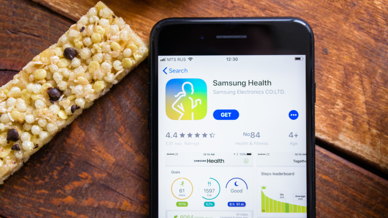 A phone with the Samsung Health app and a granola bar beside it.