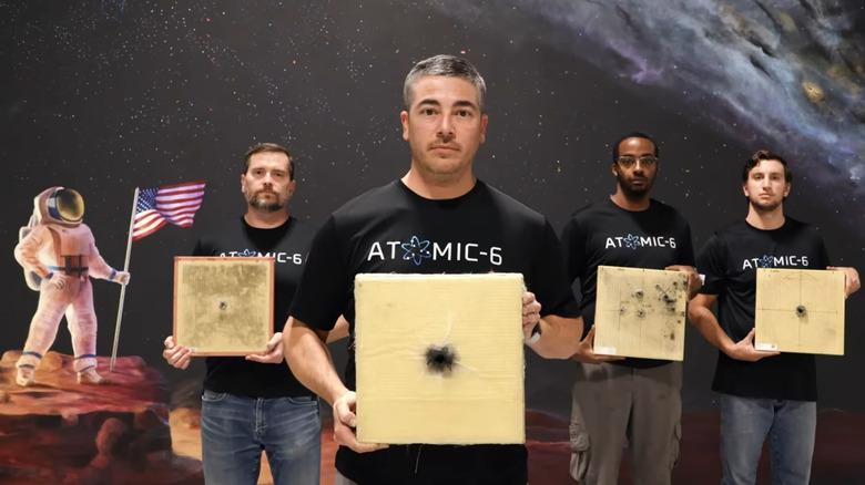 Atomic-6 employees holding up Space Armor testing tiles.