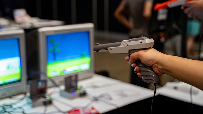 A hand holding the Nintendo Zapper while playing a video game