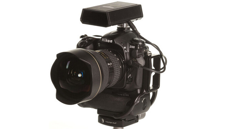 Nikon camera fitted with a lightning trigger against a white background