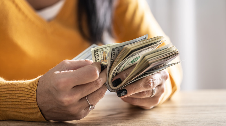 a woman counts money in her hand