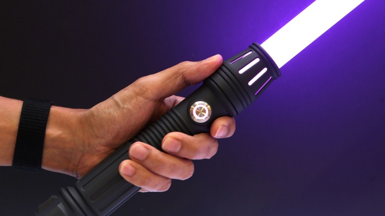 Person holding Adafruit 3d printed lightsaber with purple blade