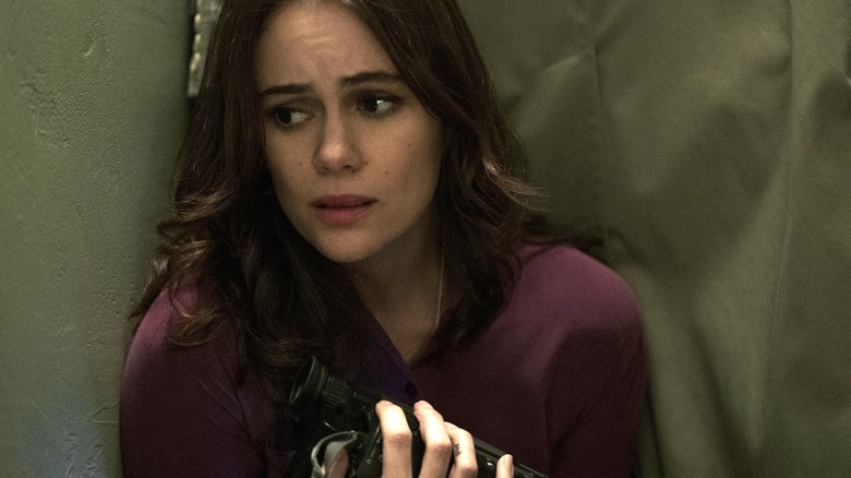 Melody frowning and holding a video camera in "Archive 81."