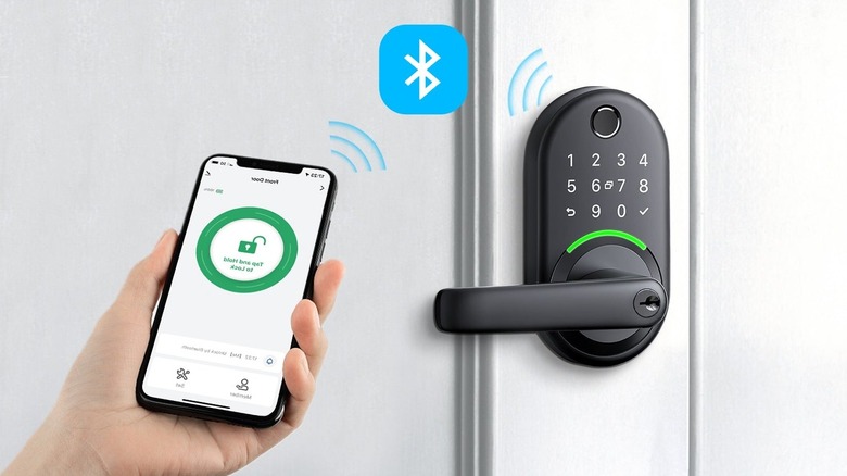 A person holding a phone with the Yamiry app on the home screen next to the smart lock