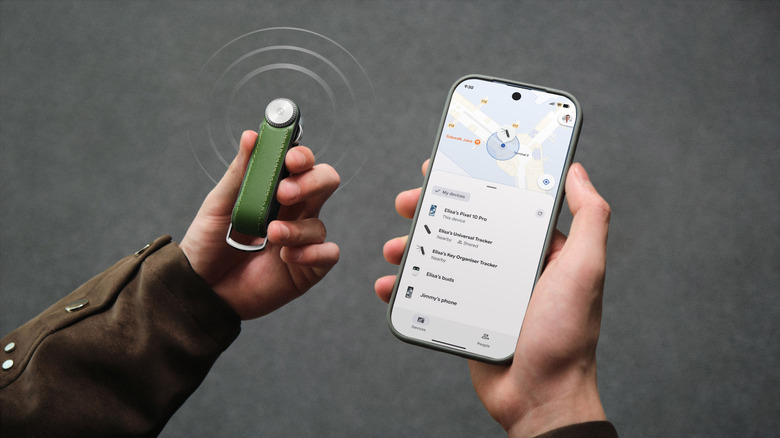Hand holding Orbitkey Key Organizer Tracker on one hand and phone showing Find Hub on the other hand