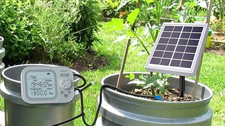 An outside photo of the Beday Solar Automatic Drip Irrigation System, the solar panel is attached to one bucket, and the control center is connected to another