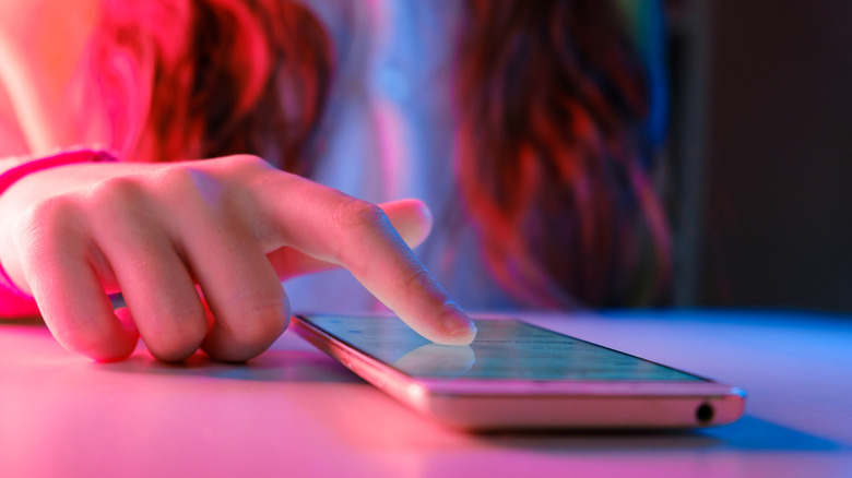 Close-up of young person's hand scrolling on phone