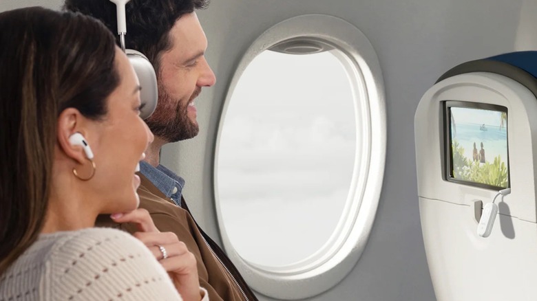 A couple on a plane using Twelve South's AirFly Pro 2 wireless receiver with their wireless headphones