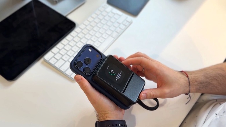 Hands holding an Ookla SpeedTest Pulse connected to the back of a smartphone.
