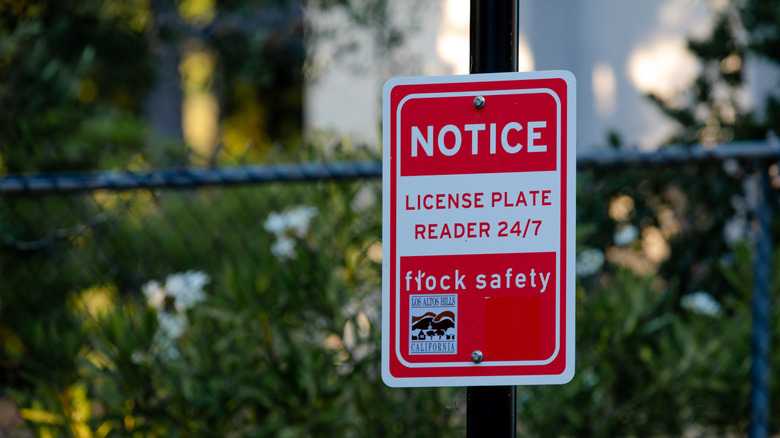 a notice sign telling the public a Flock safety camera is in use for license plate reading