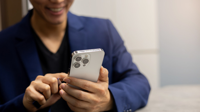 A man using an iPhone 16.
