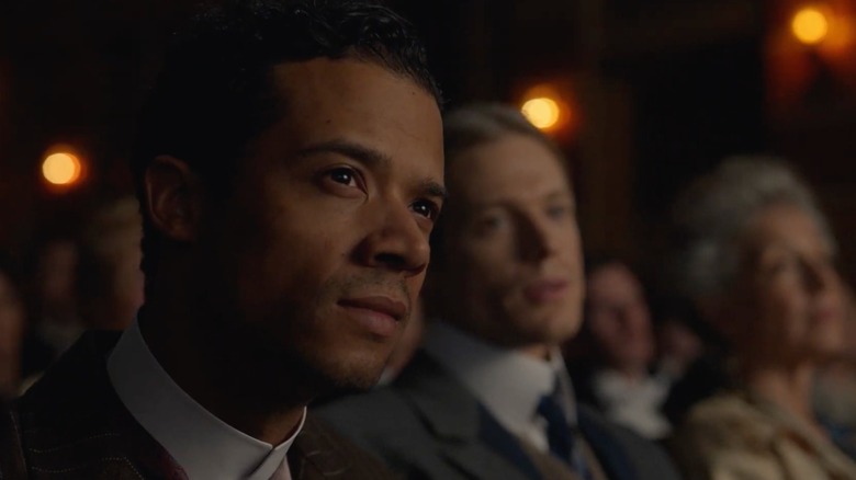 Closeup of Jacob Anderson with Sam Reid in the background in 