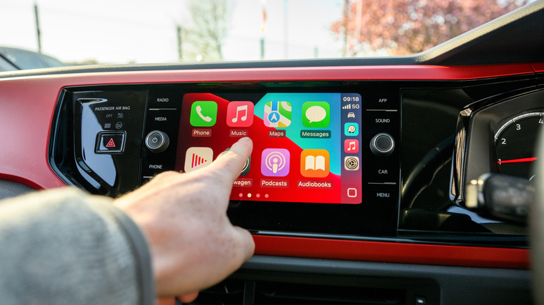 A person interacting with CarPlay in iOS 26.
