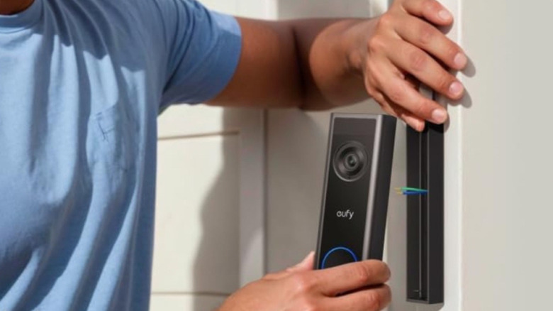 A person installing the Eufy Video Doorbell C31.