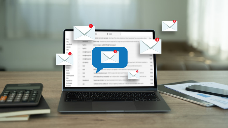 A laptop open on a blurred email inbox with notification icons over it