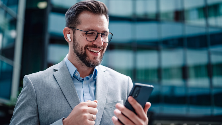 a business man talking on the phone through wireless earbuds