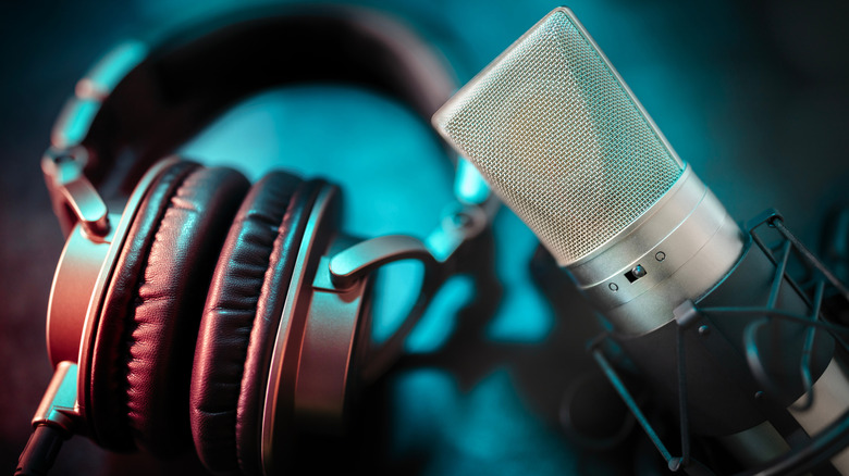 A podcast microphone next to a set of headphones