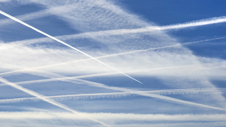 series of contrails criss crossing across the sky