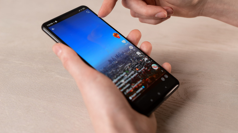 A person scrolling through TikTok videos on a smartphone.