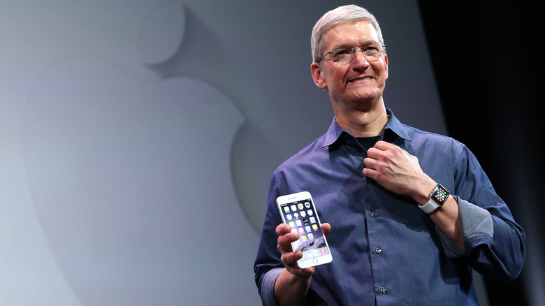 Tim Cook holding the iPhone 6 and wearing the first Apple Watch during an Apple event in September 2014.