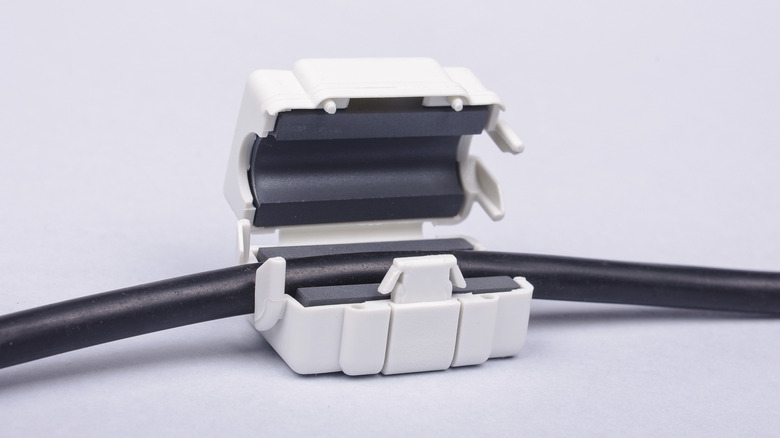 A white ferrite bead ready to be connected to a black cable