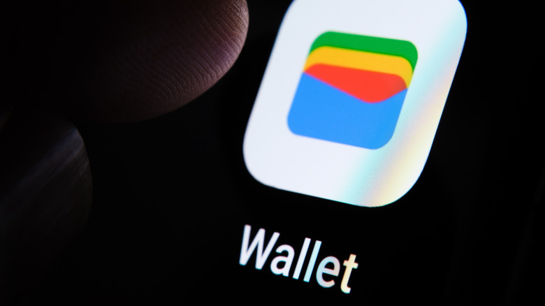 Person tapping google wallet app icon on phone