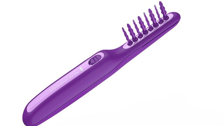 A large purple comb with twisted bristles and a large handle to store the batteries