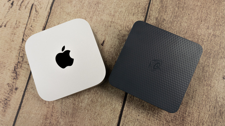 Two mini PCs against a wood backdrop