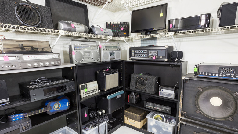 A variety of audio/visual components sitting on shelves at an electronics store
