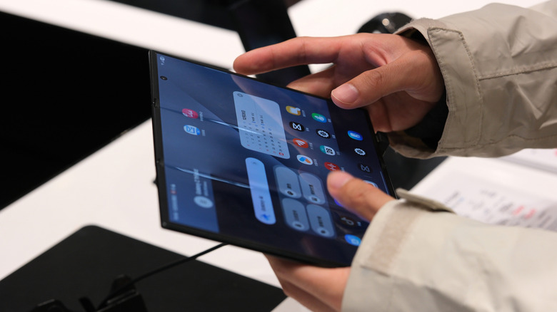 A user's hands holding and interacting with the Galaxy Z TriFold