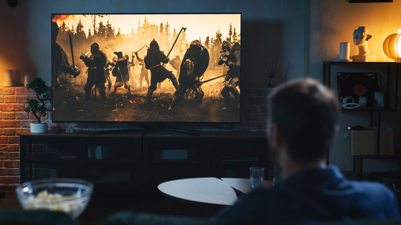 A cinephile watching a 4K movie in a home theater setup