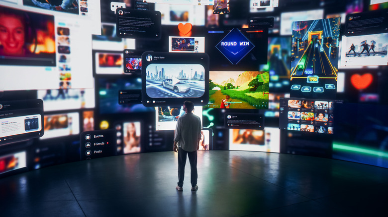 man surrounded by large TV display