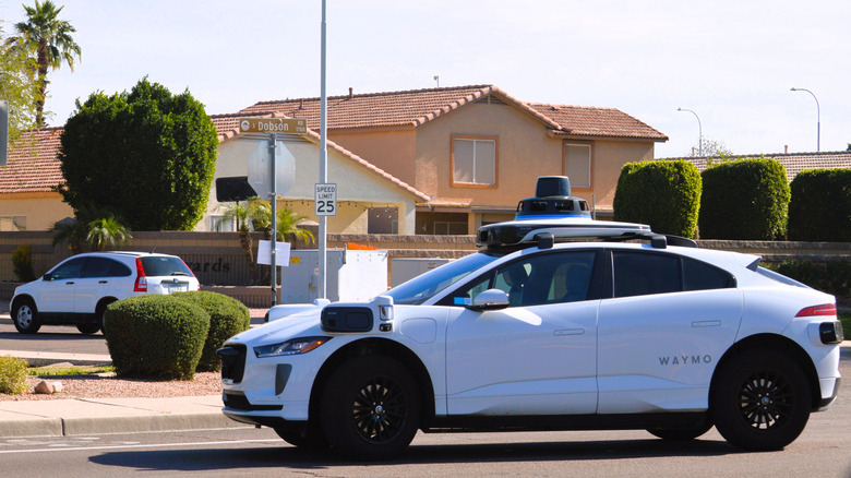 Waymo self-driving taxi moving through a Phoenix, Arizona neighborhood.
