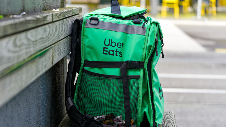 An Uber Eats delivery bag on a bench.