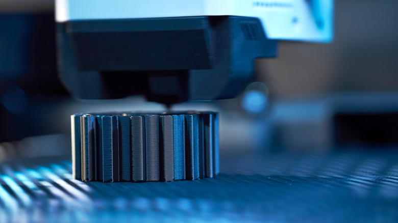 A high tech 3D printer making a metal component.