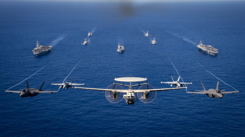Multiple U.S. Navy aircraft and ships in formation at sea