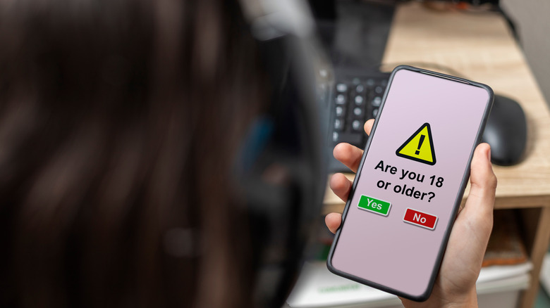 person looking at phone with age verification prompt on it