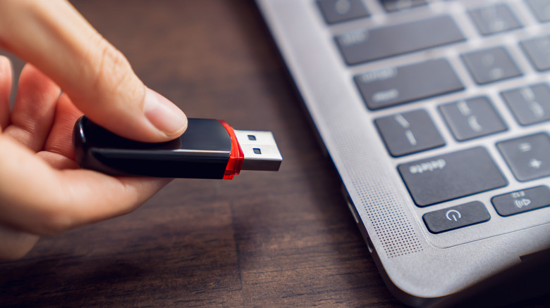 A USB flash drive being connected to a MacBook