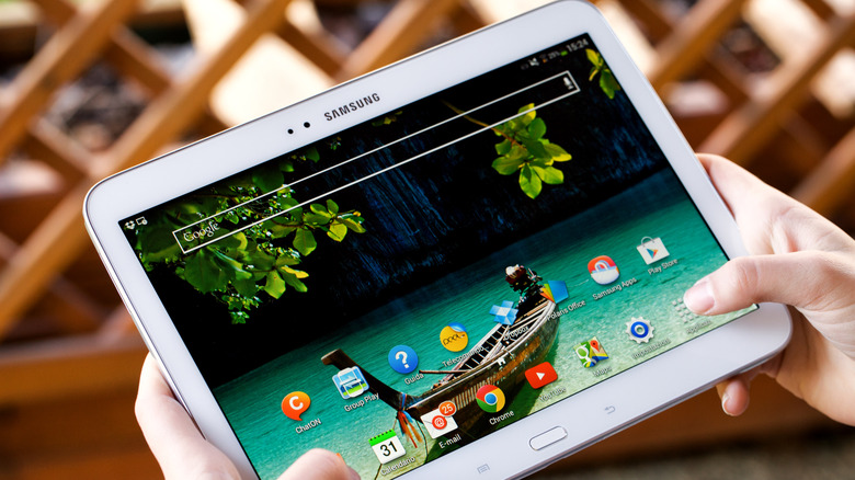 Person holding an old Samsung tablet