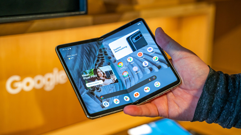 A person holding a Pixel Fold with the cover opened