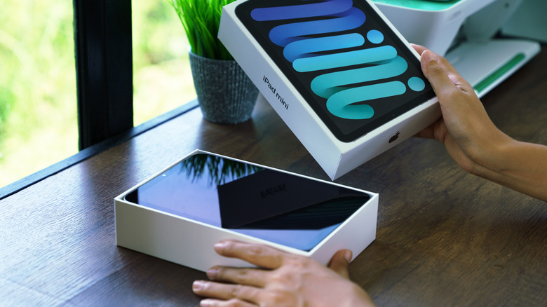 Person taking an iPad Mini out of its box.